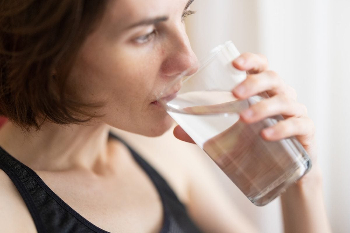Woman drinking water to relieve dry mouth at night