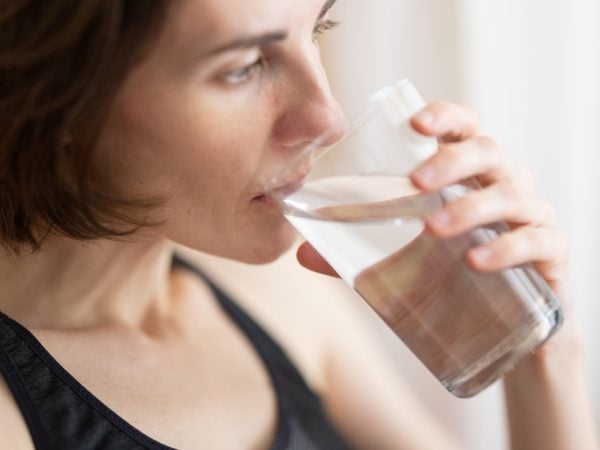 Woman drinking water to relieve dry mouth at night